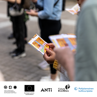 Close-up of hands holding a map. Other people are standing in the background. At the bottom, logos: Arts Promotion Centre Finland, Co-funded by the European Union, ANTI, Future DiverCities, Nordic Culture Point.